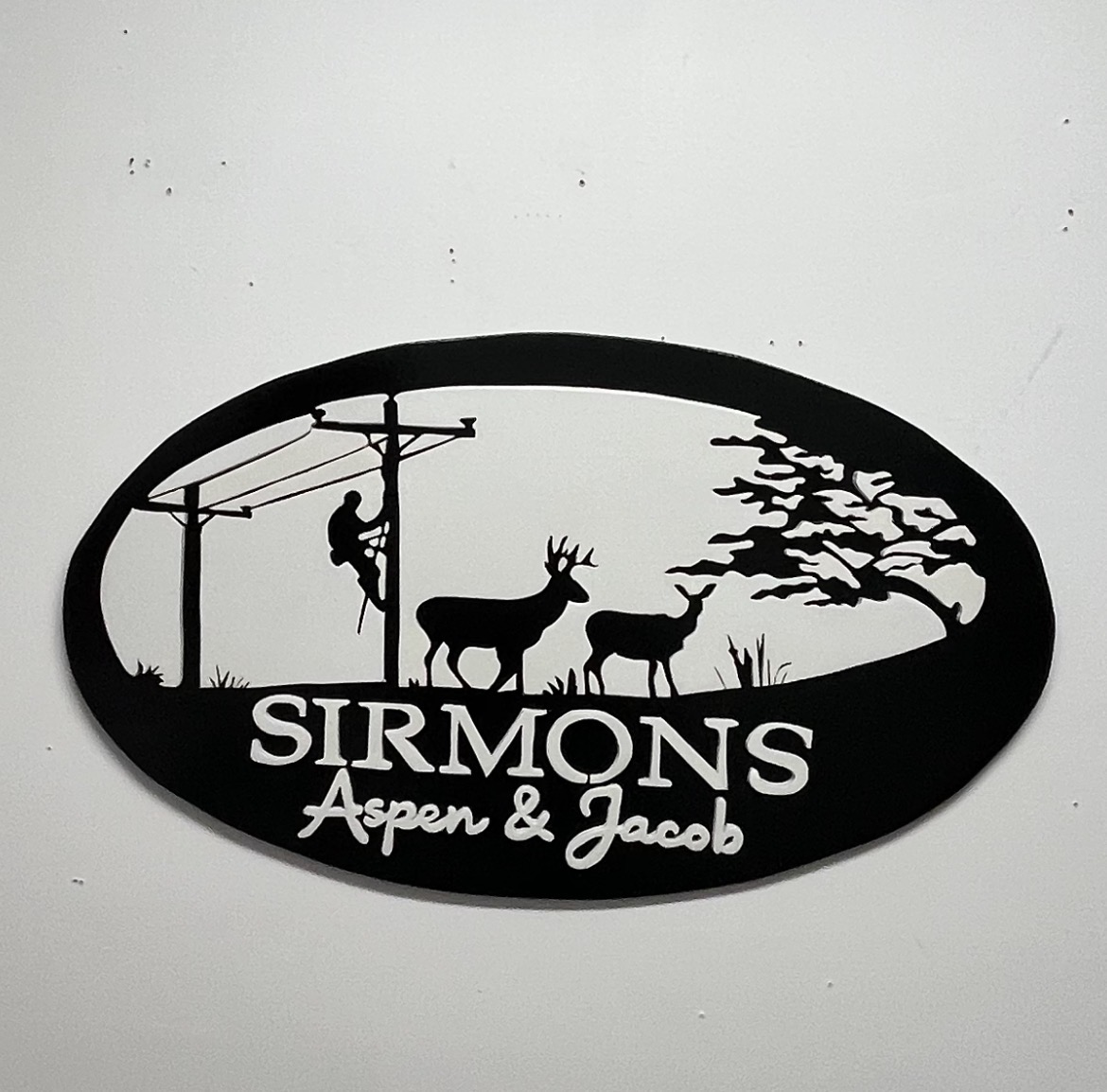 Family name sign with a hand-cut whitetail deer