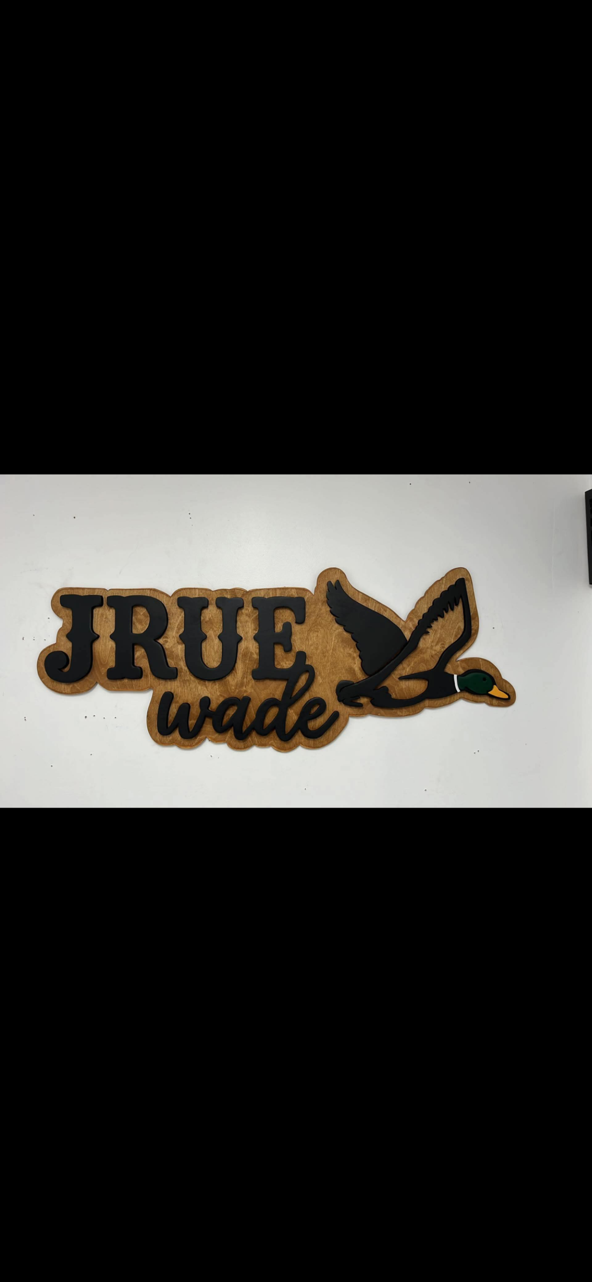 Hand-cut wooden duck sign with a name and layered cattails